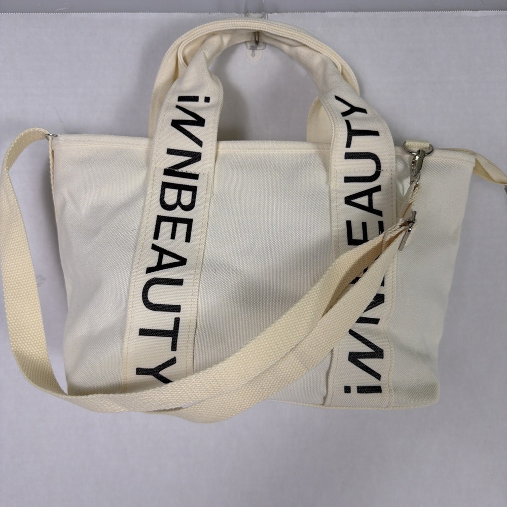 iNN BEAUTY bag off white tote bag with black letter branded straps.